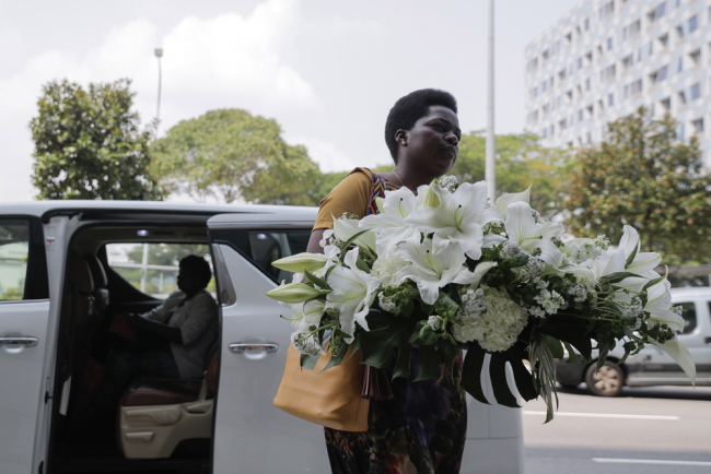 A woman carrying a wreath arrives at the Singapore Casket building, where the body of former Zimbabwean president Robert Mugabe is being held in Singapore, on September 07, 2019. [Photo: EPA via IC]