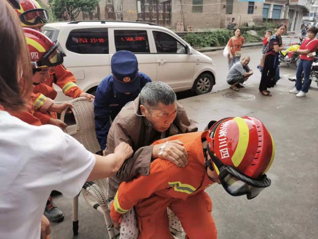 Firefighters are transferring a paralyzed senior after the 5.4-magnitude earthquake hitting Weiyuan County in Sichuan Province on September 8, 2019. [Photo: IC]