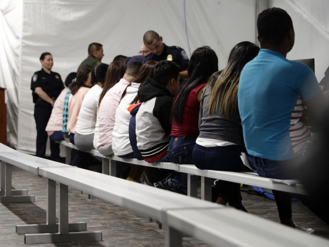 Migrants who are applying for asylum in the United States go through a processing area at a new tent courtroom at the Migration Protection Protocols Immigration Hearing Facility, Tuesday, Sept. 17, 2019, in Laredo, Texas. [Photo: AP/Eric Gay]<br>