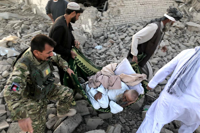 An Afghan security member and people carry an injured man after a suicide attack in Zabul, Afghanistan, Thursday, Sept. 19, 2019. A powerful early morning suicide truck bomb devastated a hospital in southern Afghanistan on Thursday. [Photo: AP via IC/Ahmad Wali Sarhadi]