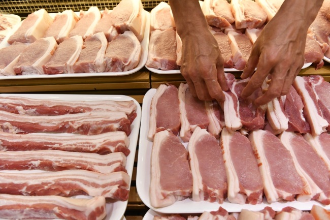 A Chinese employee puts pork and other meat products for sale at a supermarket in Nanchang City, east China's Jiangxi Province, September 4, 2019.[File Photo: IC]