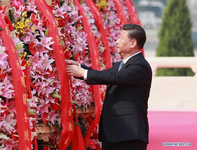 Xi Jinping straightens the red ribbons on flower baskets as he and other leaders of the Communist Party of China (CPC) and the state, including Li Keqiang, Li Zhanshu, Wang Yang, Wang Huning, Zhao Leji, Han Zheng and Wang Qishan, attend a ceremony held to pay tribute to deceased national heroes on the Martyrs' Day at the Tian'anmen Square in Beijing, capital of China, September 30, 2019. [Photo: Xinhua/Pang Xinglei]