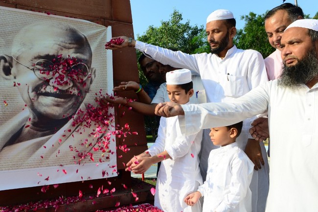 Indian Congress Party workers shower rose petals on a portrait of Indian independence icon Mahatma Gandhi during a tribute to mark his 150th birth anniversary in Amritsar on October 2, 2019. [Photo: AFP]