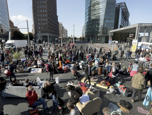 Supporters of the 'Extinction Rebellion' movement block a road at the Potsdamer Platz square in Berlin, Germany, Monday, Oct. 7, 2019. [Photo: AP /Michael Sohn]