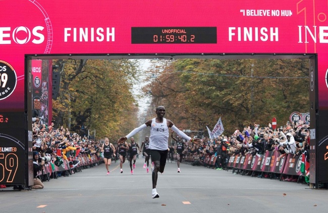 Kenya's Eliud Kipchoge (white jersey) celebrates as he crosses the finish line at the end of his attempt to bust the mythical two-hour barrier for the marathon on October 12, 2019 in Vienna. [Photo: VCG]