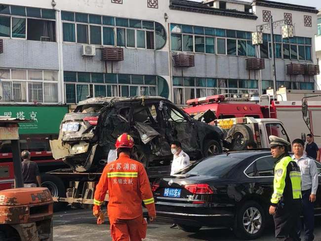 Firefighters and policemen work on shipping a car destroyed by the restaurant explosion in Wuxi city, east China's Jiangsu province, October 13, 2019. [Photo: IC]