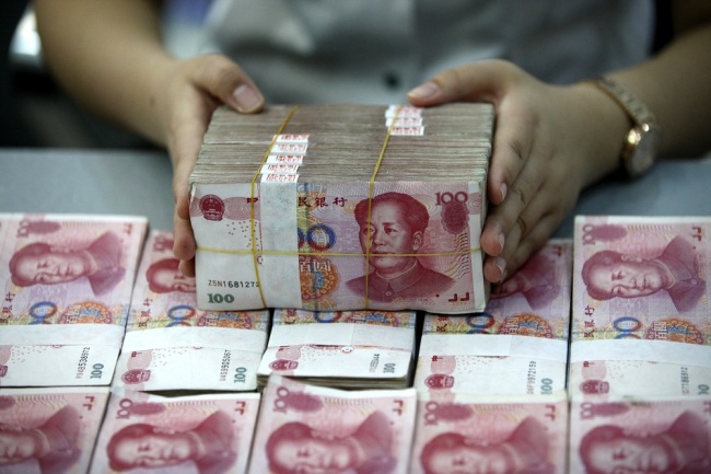 A Chinese clerk counts RMB (renminbi) yuan banknote at a bank in Huaibei City, east China's Anhui Province, August 26, 2015. [File Photo: IC]