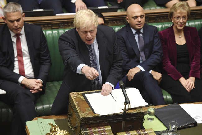 Britain's Prime Minister Boris Johnson speaks to lawmakers inside the House of Commons to update details of his new Brexit deal with EU, in London Saturday Oct. 19, 2019. At a rare weekend sitting of Parliament, Johnson implored legislators to ratify the Brexit deal he struck this week with the other 27 EU leaders. Secretary of State for Exiting the European Union, Stephen Barclay, left, and Business Secretary Andrea Leadsom, right. [Photo: Jessica Taylor/House of Commons via AP]