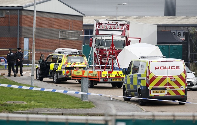 Police officers attend the scene after a truck, in rear, was found to contain a large number of dead bodies, in Thurrock, South England, early Wednesday Oct. 23, 2019. [Photo: IC]