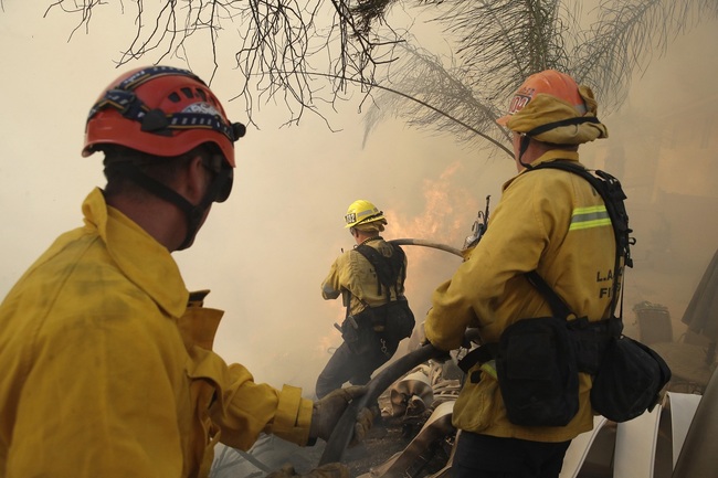 Firefighters make a stand as a wildfire approaches the backyard of a home Thursday, Oct. 24, 2019, in Santa Clarita, California. [Photo: Christian Monterrosa via IC]