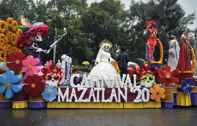 People take part in the Day of the Dead parade along Reforma avenue in Mexico City, on October 27, 2019. [Photo: AFP/Claudio Cruz]