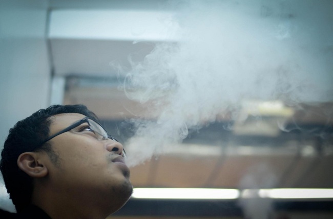 A man smokes electronic cigarettes at a mall. [File Photo: VCG]