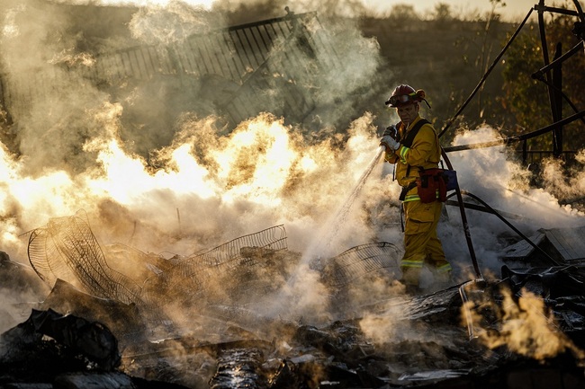 Firefighters mop up a wreckage of burned down home destroyed by the Hillside Fire in San Bernardino, Calif., on Oct. 31, 2019. [Photo：VCG/Los Angeles Times/Getty Images/Marcus Yam]