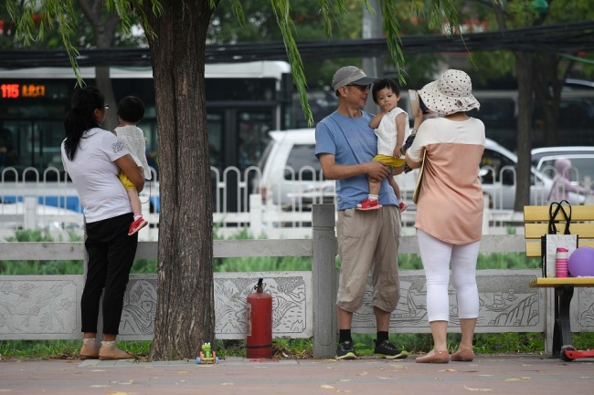 A family takes photos at a residential area in Beijing on August 28, 2018. [File Photo: VCG]