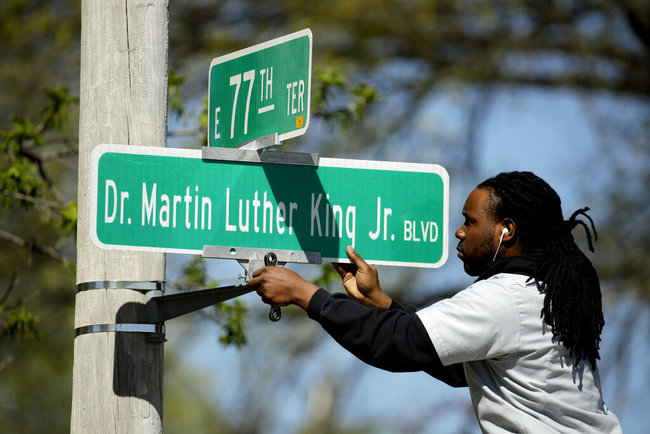 In this April, 20, 2019, file photo, public works employee Jerry Brooks changes a street sign from The Paseo to Dr. Martin Luther King Jr. Blvd. in Kansas City, Mo. [File photo: AP]