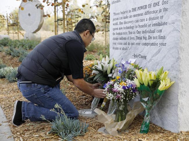 A visitor presents a flower bouquet in front of a tablet inscribed with an introduction of Iris Chang at a memorial park named after the late Chinese-American writer in San Jose, California, the United States, Nov. 9, 2019. [Photo: VCG]