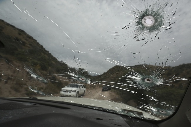 File Photo: Bullet-riddled vehicles that members of the extended LeBaron family were traveling in sit parked on a dirt road near Bavispe, at the Sonora-Chihuahua state border, Mexico, Wednesday, Nov. 6, 2019. [Photo: AP/Christian Chavez]