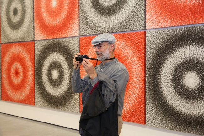 A visitor takes a picture of artist Meng Luding's art pieces at his solo exhibition which opened in Beijing on Saturday, Nov 16, 2019.[Photo: China Plus]