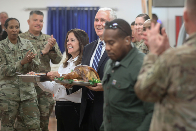 U.S. Vice President Mike Pence and his wife Karen Pence help to serve a Thanksgiving meal to U.S. troops in a dining facility at Camp Flores on Al Asad Air Base, Iraq November 23, 2019.[Photo: VCG]