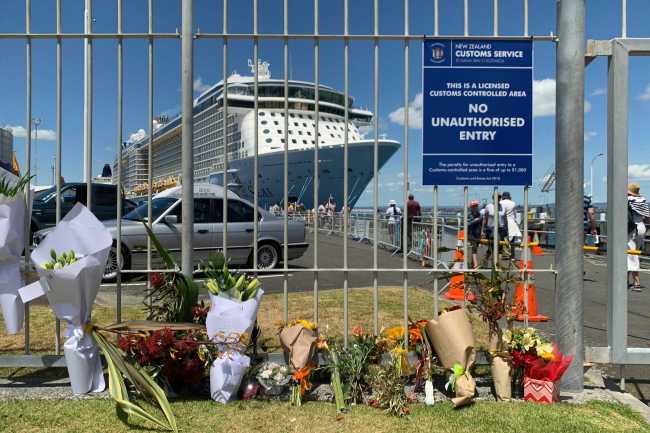 Flowers are laid on makeshift memorial is seen in front of cruise ship Ovation of the Seas, in Tauranga, New Zealand, Tuesday, Dec. 10, 2019. [Photo: AP /Nick Perry]
