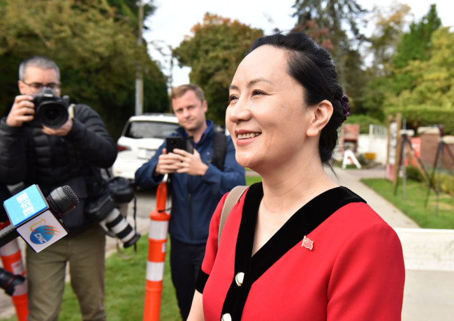 Huawei Chief Financial Officer, Meng Wanzhou, stops to talk to media while leaving her Vancouver home to appear in British Columbia Supreme Court, in Vancouver, on October 1, 2019. [File photo: AFP/Don MacKinnon]