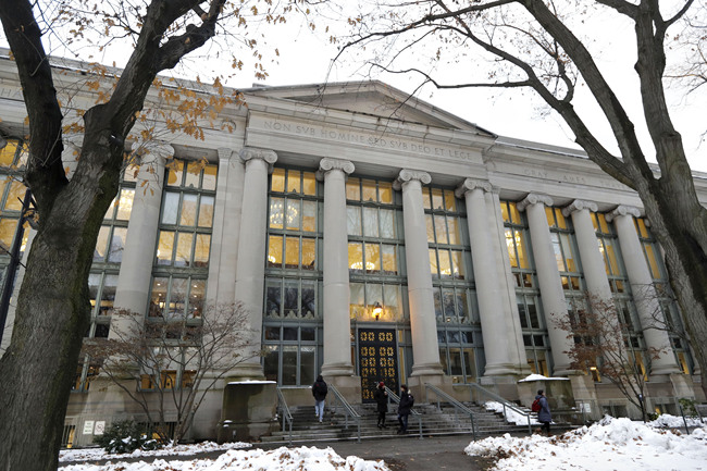 Passers-by walk near an entrance to a building at Harvard Law School, in Cambridge, Mass on Thursday, Dec. 5, 2019. [Photo: AP/ Steven Senne]