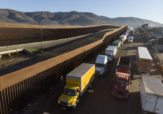 Aerial view of trucks lining up near the border fence to cross to the United States at Otay Commercial port of entry in Tijuana, Baja California state, Mexico, on December 10, 2019. [Photo: AFP]