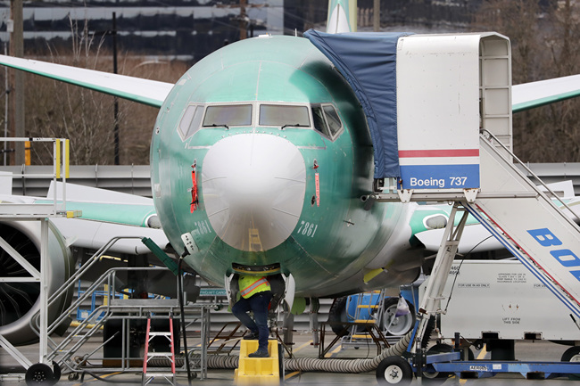 A worker looks up underneath a Boeing 737 MAX jet Monday, Dec. 16, 2019, in Renton, Wash. [File photo: AP/Elaine Thompson]