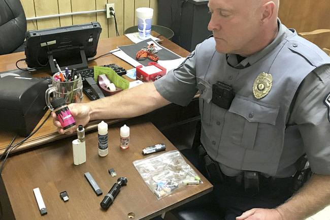 In this Sept. 23, 2019 photo, Bristol, Va., Police Officer Marlin Goff shows some of the vaping products he has confiscated from students at a high school. [Photo: AP]