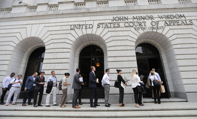 In this Tuesday, July 9, 2019 file photo, People wait in line to enter the 5th Circuit Court of Appeals to sit in overflow rooms to hear arguments in New Orleans. The "individual mandate" of former President Barack Obama's health care law is invalid, but other parts of the law need further review, a federal appeals court ruled Wednesday, Dec. 18, 2019. [File photo: AP/Gerald Herbert]