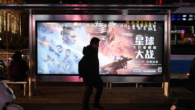 This photo taken on December 19, 2019 shows a man walking past a poster for the latest Star Wars movie, "The Rise of Skywalker", in Beijing. The movie opens in theaters in China on December 20. [Photo: AFP]