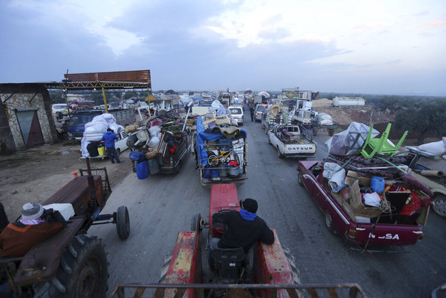 Truckloads of civilians flee a Syrian military offensive in Idlib province on the main road near Hazano, Syria, Tuesday, Dec. 24, 2019. [Photo: AP]