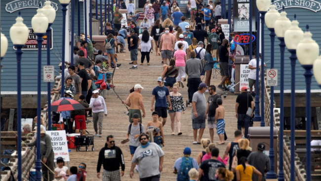 22. června 2020 během pandemie COVID-19 je na plážovém molu na pobřeží v Kalifornii v USA vidět jen pár lidí, kteří nosí roušky. / Reuters