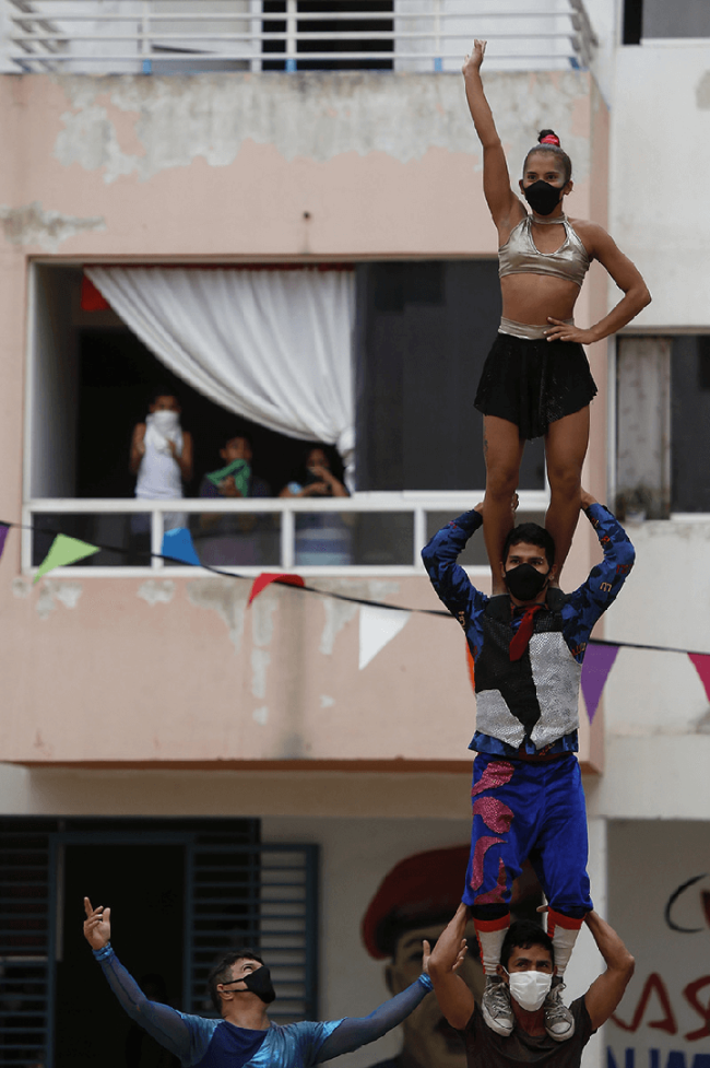 Snímek: Členové venezuelského národního cirkusu vystupují pro obyvatele, kteří musí zůstat doma v Karakasu ve Venezuele; 24. března 2020. / Xinhua