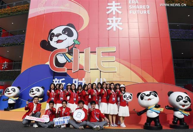 4, Dobrovolníci pózují pro skupinovou fotografii před dekoracemi v Národním výstavním a kongresovém centru (Šanghaj), hlavním místě konání třetího Čínského mezinárodního dovozního veletrhu (CIIE), ve východočínské Šanghaji, 10. listopadu 2020. Expo podle plánu potrvá do 10. listopadu. Zaměstnanci, vystavovatelé a návštěvníci fotografují, aby si uchovali vzácné okamžiky akce. (Xinhua / Zhao Dingzhe)