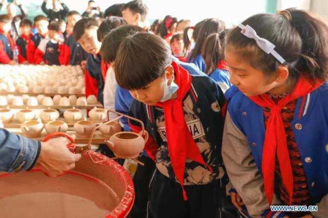 2, Žáci základní školy se dívají na proces výroby porcelánových prací v dílně porcelánu Ru (Žu) v okrese Baofeng (Pao-feng) v provincii Henan (Che-nan) ve střední Číně. Okres Baofeng je známý výrobou porcelánu Ru, jednoho z pěti známých porcelánů během dynastie Song (Sung, 960-1279) ve starověké Číně. Více než 90 studentů základní školy Xichengmen (Si-čcheng-men) v okrese Baofeng se zde v neděli zúčastnilo praktické aktivity, kde se dozvěděli o porcelánu Ru. (Foto He Wuchang / Xinhua)