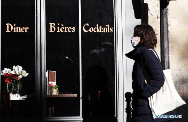 Žena s rouškou prochází kolem uzavřené restaurace v Paříži, 18. listopadu 2020. Francie se v úterý stala první evropskou zemí, která zaznamenala více než dva miliony potvrzených případů COVID-19, i když se epidemické ukazatele postupně zlepšují, uvedl generální ředitel pro zdraví Jerome Salomon. (Xinhua / Gao Jing)