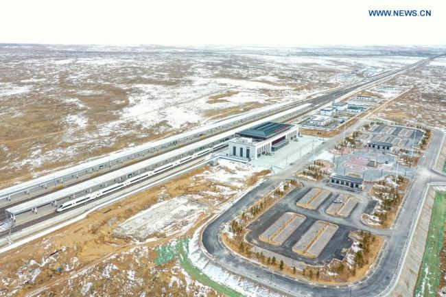 Letecký snímek pořízený 12. prosince 2020 ukazuje vlak stojící na nádraží Huianbu (Chuej-an-pu) během zkušebního provozu vysokorychlostní železnice Yinchuan (Jin-čchuan) - Xi'an (Si-an). Vysokorychlostní železnice Yinchuan-Xi'an má být uvedena do provozu (Xinhua / Feng Kaihua)