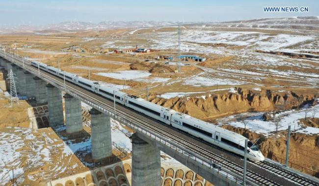 Letecký snímek pořízený 12. prosince 2020 zachycuje vlak jedoucí přes velký most Mafanggou (Ma-fang-kou) během zkušebního provozu vysokorychlostní železnice Yinchuan (Jin-čchuan) - Xi'an (Si-an). Vysokorychlostní železnice Yinchuan-Xi'an má být uvedena do provozu. (Xinhua / Chen Bin)