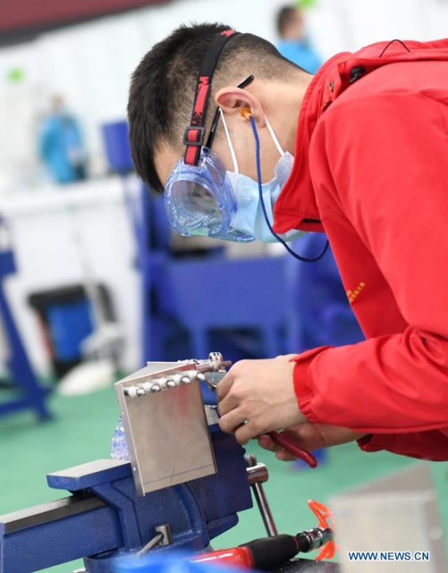 Soutěžící se účastní akce údržby letadel v druhý den první soutěže odborných dovedností Čínské lidové republiky, která se konala 11. prosince 2020 v Kantonu v jihočínské provincii Guangdong (Kuang-tung). (Xinhua / Lu Hanxin)