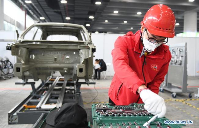 Soutěžící se účastní akce údržby automobilů v druhý den první soutěže odborných dovedností Čínské lidové republiky, která se konala 11. prosince 2020 v Kantonu v jihočínské provincii Guangdong (Kuang-tung). (Xinhua / Lu Hanxin)