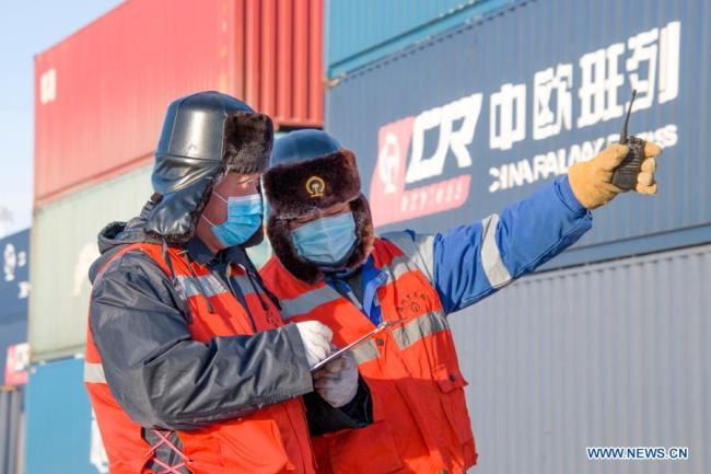 Zaměstnanci kontrolují 30. prosince 2020 informace o kontejnerech v Manzhouli v severočínské autonomní oblasti Vnitřní Mongolsko. Počet čínsko-evropských nákladních vlaků, které přijíždějí a odjíždějí přes Manzhouli, největší čínský pozemní přístav, dosáhl v roce 2020 rekordu i přes dopad COVID-19, uvedly ve středu místní železniční úřady. (Foto: Guo Nailun / Xinhua)