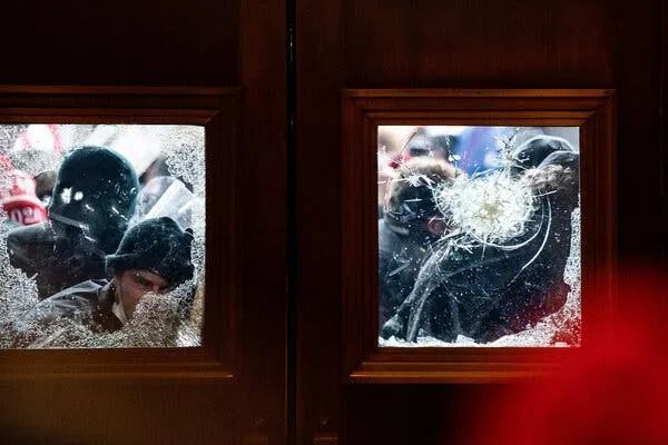Lidé ve středu bouchali na skleněná okna, davy se valily kolem předních sloupů, a další pomocí sloupů otloukali vchod do budovy. / The New York Times