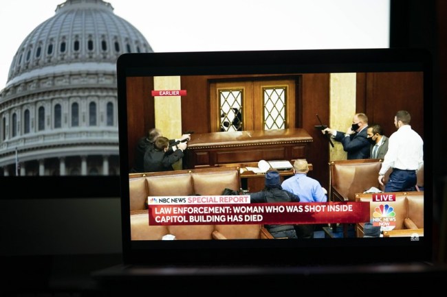 Pracovníci bezpečnosti v budově amerického Kapitolu reagují na chaotickou situaci ve videozáznamu ze zpráv NBC přehrávaného 6. ledna 2021 na obrazovce v Arlingtonu ve Virginii ve Spojených státech. (Xinhua / Liu Jie)
