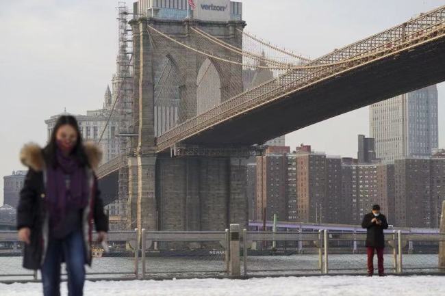 Lidé prochází pod Brooklynským mostem v New Yorku, v Spojených státech, 21. prosince 2020. (Xinhua / Wang Ying)