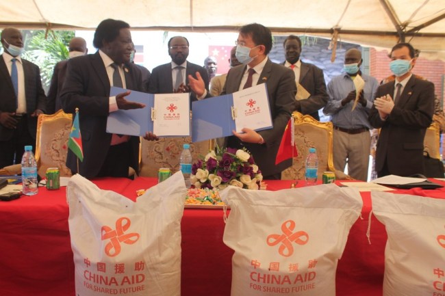Vlevo Mnaseh Lomole předseda jihosúdánské komise pro pomoc a zotavení s čínským velvyslancem v Jižním Súdánu Hua Ningem (vpravo) si během ceremoniálu předávání čínských potravin vyměňují dokumenty, Juba, Jižní Súdán, 17. září 2020. (Photo/Xinhua)