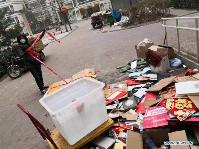 (210211) - PEKING, 11. února 2021 (Xinhua) - Pracovník recykluje použité plastové lahve a obaly v obytné čtvrti v Pekingu, hlavním městě Číny, 11. února 2021. Lidé z různých odvětví zastávají své funkce v předvečer čínského lunárního Nového roku, neboli Jarního svátku, který připadá na 12. února. (Xinhua / Lan Hongguang)