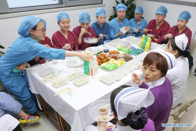 Zdravotničtí pracovníci z oddělení pohotovosti jedí v kanceláři v nemocnici Peking Union Medical College Hospital, v Pekingu, hlavním městě Číny, 11. února 2021. Letošní Jarní svátek připadá na pátek. (Xinhua / Zhang Yuwei)