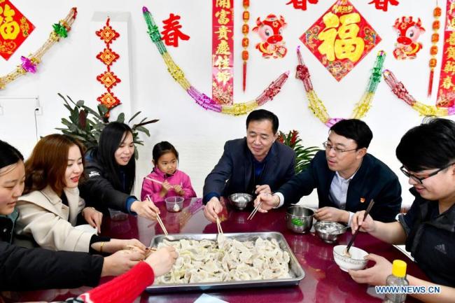 Železniční dělníci, kteří se rozhodli na svátky nevracet domů, čímž podporují vládní výzvu k omezenému cestování kolem lunárního Nového roku, aby se omezilo rozšíření COVID-19, si pochutnávají na knedlících ve městě Jinan (Ťi-nan) v provincii Shandong (Šan-tung) ve východní Číně, 10. února 2021. Lunární Nový rok patří k nejvýznamnějším svátkům v Číně a oslavné činnosti jsou rozmanité, včetně jídla. Když přichází lunární Nový rok, lidé po celé Číně připravují různá občerstvení, která, jak věří, jim přinesou štěstí. (Xinhua / Guo Xulei)