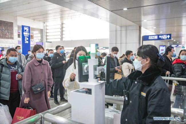 Cestující se registrují na nádraží Chongqing-sever (Čchung-čching) ve městě Chongqing v jihozápadní Číně, 17. února 2021. Ve středu je poslední den Jarních svátků. Železniční nádraží vstoupila do špičky vracejících se cestujících a železniční oddělení Chongqing podniklo opatření, aby cestující mohli cestovat snadno a bezpečně. (Xinhua / Huang Wei)